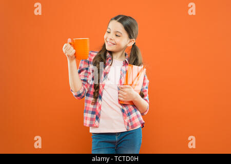 Dépenser temps agréable avec livre préféré. Fille tenir une tasse de thé et d'adresses. La littérature pour enfants. Aime passer du temps à la maison. Cacao chaud et bon livre idéal pour soirée agréable. Lecture bucket list. Banque D'Images