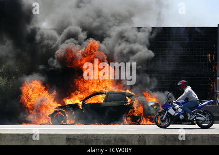 Lisbonne, Portugal. 10 Juin, 2019. Une voiture est consommée par les flammes sur l'autoroute 5 (A5) qui relie Lisbonne et Cascais, à Linda-a-Velha, Oeiras, Portugal, le 10 juin 2019. Les pompiers n'avait pas de dossier sur les blessures en raison de l'accident. Credit : Petro Fiuza/Xinhua/Alamy Live News Banque D'Images