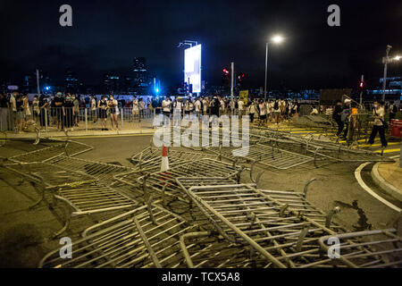 Barrières métalliques sont placés au milieu de la route par les manifestants afin de former une ligne de défense de la police. Dans les premières heures du 10 juin, des centaines de manifestants se sont affrontés avec la police que les manifestants ont tenté de s'est produite lors de l'entrée du bâtiment où le conseil législatif le conseil législatif les membres sont mis au vote sur le projet de loi sur l'extradition le 12 juin. Les affrontements ont provoqué au moins 15 personnes blessées y compris protestataires, agent de police et des membres de la presse. Des centaines de milliers de manifestants sont descendus dans la rue de Hong Kong le 9 juin Banque D'Images
