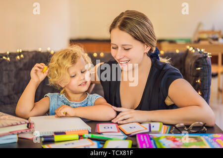 Un professeur, un tuteur pour l'enseignement à domicile, et un professeur à la table. Ou maman et sa fille. Homeschooling Banque D'Images