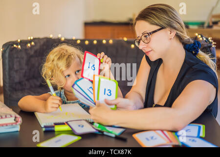 Un professeur, un tuteur pour l'enseignement à domicile, et un professeur à la table. Ou maman et sa fille. Homeschooling Banque D'Images