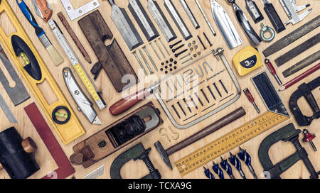 Vue d'un ensemble d'outils de menuisier sur un fond de bois. Mise à plat de style. Banque D'Images