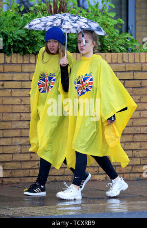 Deux étudiants d'échange allemand brave la pluie torrentielle sur la promenade, à Eastbourne, dans le Sussex, comme le prédit la pluie balaie le sud-est. Banque D'Images