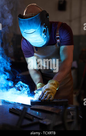 Méconnaissable dans workman casque et gants de protection à l'article 24 et de soudage avec une torche en métal Banque D'Images