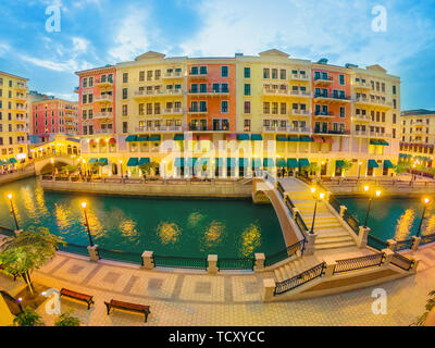 Vue grand angle de deux ponts sur les canaux de Venise quartier pittoresque de Doha l'icône illuminée la nuit. Panorama de Venise au Quartier Qanat, le Banque D'Images