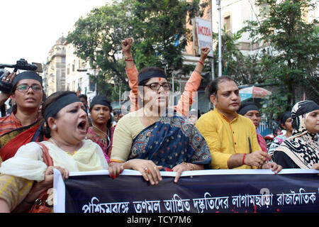 MP BJP Médaillon Chatterjee est titulaire d'une bannière avec BJP travailleurs féminins pendant la manifestation de Kolkata. Au moins quatre personnes ont été tuées et trois autres gravement blessés dans les affrontements qui ont éclaté entre l'Inde et de tous les congrès Trinamool Bhartiya Janata partisans dans Basirhat au Nord 24 Parganas district sur samedi soir. Il est affirmé que les affrontements ont éclaté au cours de la dépose de drapeaux des partis politiques. Le secrétaire général de l'état BJP Sayantan Basu dit, trois travailleurs Parti BJP Sukanta Mondal, Pradip Mondal et Shankar Mondal est mort dans cet affrontement. Banque D'Images