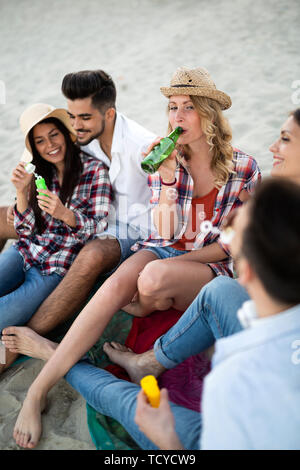 Les amis à faire la fête et s'amuser sur la plage à l'été Banque D'Images