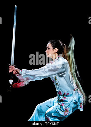 Une femme chinoise Tai Chi Chuan partacticing Tadjiquan posture studio shot isolé sur fond noir avec effet light painting Banque D'Images