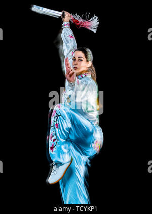 Une femme chinoise Tai Chi Chuan partacticing Tadjiquan posture studio shot isolé sur fond noir avec effet light painting Banque D'Images