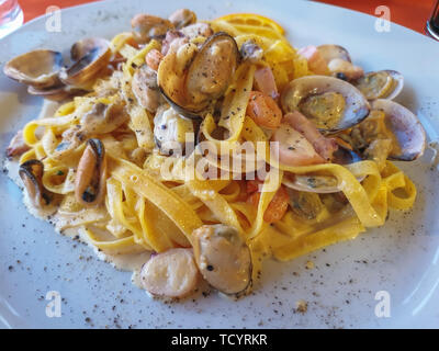 Image de pâtes aux fruits de mer en plaque blanche avec lumière douce, l'angle de vue. Spaghettis ai Frutti di mare, fruits de mer gastronomie méditerranéenne Banque D'Images