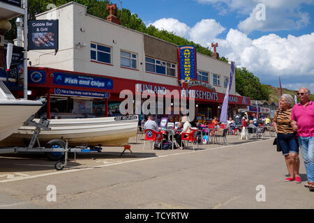 Les touristes profitant d'une chaude journée ensoleillée sur le coble atterrissage à filey bay yorkshire angleterre Banque D'Images