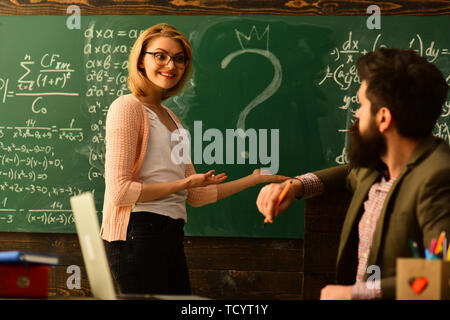 L'enseignant moderne écrit hipster sur grand tableau noir avec formule mathématique, l'enseignant respecte les élèves, les étudiants adultes Smiling in classroom interi Banque D'Images