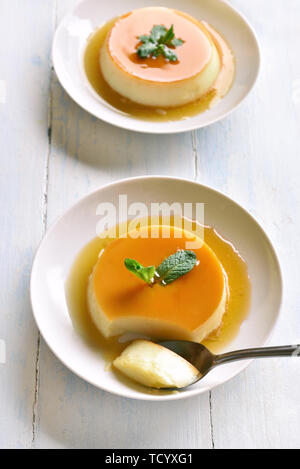 Crème caramel au lait savoureux sur plaque sur table en bois Banque D'Images