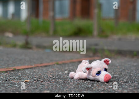 Un jouet pour enfant se trouve sur le sol à l'extérieur certains barricadèrent maisons abandonnées sur la High Street estate à Pendleton, Salford, Greater Manchester, UK. Banque D'Images