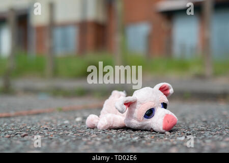 Un jouet pour enfant se trouve sur le sol à l'extérieur certains barricadèrent maisons abandonnées sur la High Street estate à Pendleton, Salford, Greater Manchester, UK. Banque D'Images