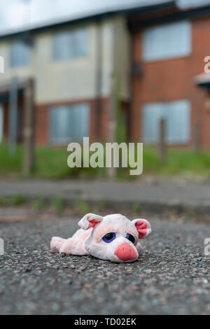 Un jouet pour enfant se trouve sur le sol à l'extérieur certains barricadèrent maisons abandonnées sur la High Street estate à Pendleton, Salford, Greater Manchester, UK. Banque D'Images