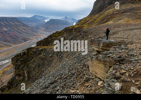 Randonnées femme restant au bord du Svalbard paysage de montagne, Vue du dessus à la fin de l'automne de Longyearbyen Banque D'Images