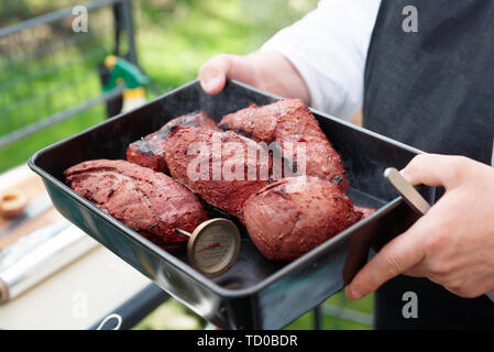 Chef holding un plateau avec la viande cuite, outdooe shot Banque D'Images