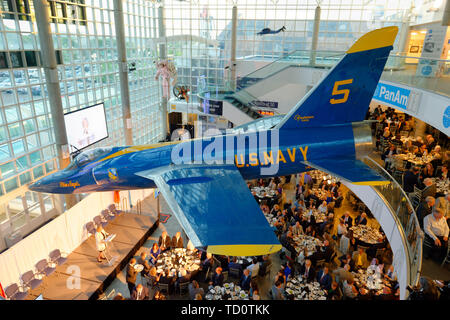 Garden City, New York, USA. 6 juin, 2019. Sur scène, le président parle de rôle des employés dans la mission Apollo Grumman est vu de troisième niveau d'atrium de berceau de l'Aviation Museum, au cours Apollon à 50 Anniversaire Dîner, un astronaute Apollo hommage célébrant la mission Apollo 11 Lune de l'atterrissage. Les Blue Angels de la Marine américaine Grumman F-11A Tiger jet est suspendu du plafond. Credit : Ann Parry/ZUMA/Alamy Fil Live News Banque D'Images