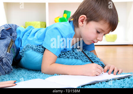 Cute little boy dessin dans son album Banque D'Images