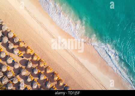 Vue de dessus de l'antenne sur la plage. Parapluies, le sable et les vagues de la mer Banque D'Images