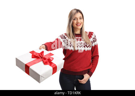 Jeune femme joyeuse portant un chandail et tenant un présent isolé sur fond blanc Banque D'Images