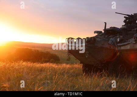 Deux Strykers du 1er Escadron, 2e régiment de cavalerie s'asseoir au sommet d'une colline donnant sur le site d'un exercice de tir réel (Sabre) au cours de LFX Guardian 2019 en Hongrie, le 5 juin 2019. Les Strykers composent le Centre d'action tactique (TAC) permettant à l'équipe de commandement de maintenir le contrôle de mission tout en se déplaçant sur l'espace de combat. SG19 est un exercice mené conjointement par les forces terrestres de l'armée américaine et l'Europe, qui se tiendra du 3-24 juin à divers endroits en Bulgarie, en Hongrie, et la Roumanie. SG19 est conçu pour améliorer l'intégration des forces de combat multinationales. (U.S. Photo de l'armée par la CPS. Nyatan Bol) Banque D'Images