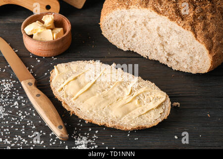 Les planches à découper, pain, sel, beurre et couteau sur fond de bois, gros plan Banque D'Images