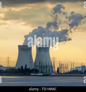 Rivière avec nuclear power plant Doel pendant un coucher de soleil avec des cluds, Port d'Anvers, Belgique Banque D'Images