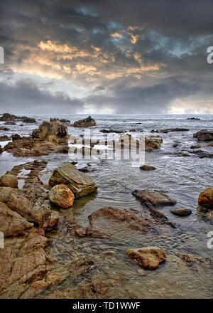 Mer calme avec des pierres juste avant une tempête, l'île de Hainan, Chine Banque D'Images