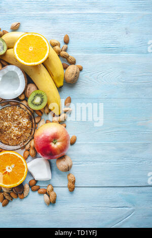 Végétalien sain Aliments crus sur fond en bois bleu. Les fruits et les noix avec du miel sur la table. Les matières organiques naturelles dessert sucré. Place pour le texte Banque D'Images