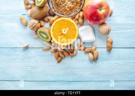 Végétalien sain Aliments crus sur fond en bois bleu. Les fruits et les noix avec du miel sur la table. Les matières organiques naturelles dessert sucré. Place pour le texte Banque D'Images