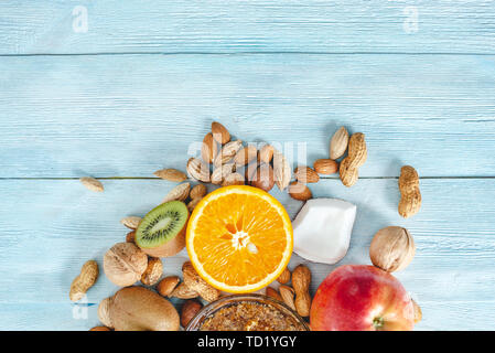 Végétalien sain Aliments crus sur fond en bois bleu. Les fruits et les noix avec du miel sur la table. Les matières organiques naturelles dessert sucré. Place pour le texte Banque D'Images