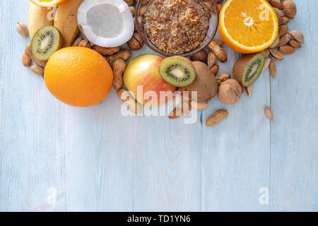 Végétalien sain Aliments crus sur fond en bois bleu. Les fruits et les noix avec du miel sur la table. Les matières organiques naturelles dessert sucré. Place pour le texte Banque D'Images