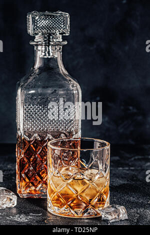 Les verres de whisky avec un carré carafe sur une pierre noire. Banque D'Images