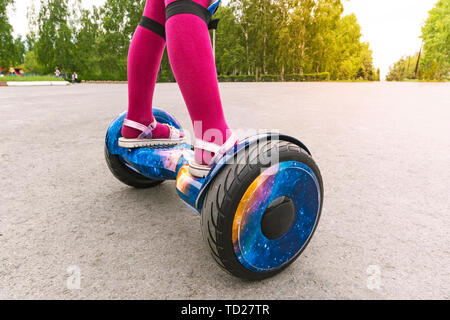 Girl rides on gyroscooter. pieds d'une petite fille en rose collant et sandales sont sur un GyroScooter Banque D'Images
