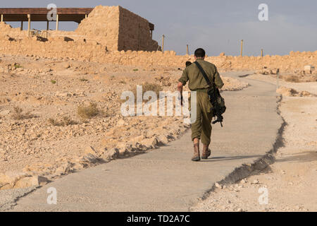 Vue arrière de l'armée allant seul parmi des territoire déserté quelque part au Moyen-Orient. Fortification de Massada, Israël, guerre trainning. Soldat fatigué Banque D'Images