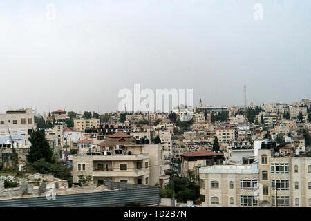 Toits d'une ville vu de dessus, en Israël. Vue aérienne de la ville au fond de ciel brumeux blanc. Tôt le matin, la vie urbaine. Ville tranquille au lever du soleil Banque D'Images