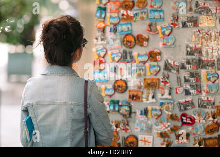 Femelle choisit un tourisme attractif dans un magasin de souvenirs Banque D'Images