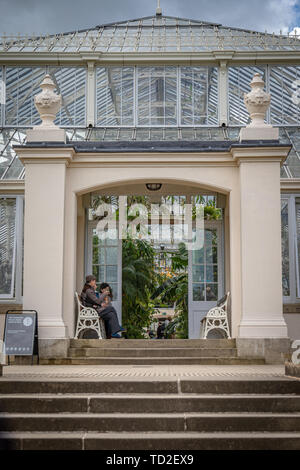 Les touristes en faisant une pause sur le banc dans l'entrée de l'aile nord de l'Europe chambre à Kew Gardens. Banque D'Images