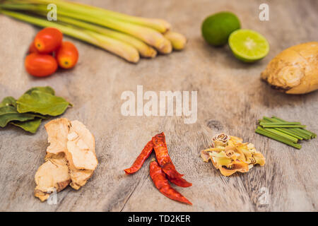 Ingrédients pour soupe Thaï populaire Tom-yum kung. La chaux, galanga, piment, tomate cerise, de la citronnelle et des feuilles de lime kaffir sur tableau noir . Mise à plat Banque D'Images