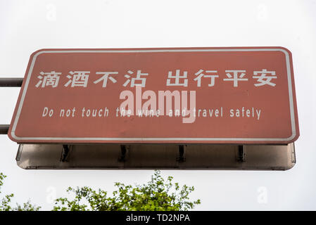 Ne touchez pas le vin et voyager en toute sécurité un signe en chinois et anglais photographié dans la ville de Dujiangyan, province du Sichuan, Chine Banque D'Images