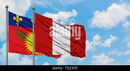 Guadeloupe et de brandir le drapeau du Pérou dans le vent contre ciel bleu nuageux blanc ensemble. Concept de diplomatie, de relations internationales. Banque D'Images