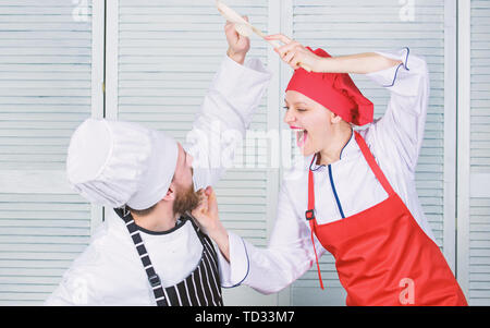 Bataille de deux chefs culinaires. Couple en compétition en arts culinaires Cuisine règles. Qui mieux cuisiner. Bataille culinaire concept. Femme et homme barbu show culinaire concurrents. Cuisine ultime défi. Banque D'Images