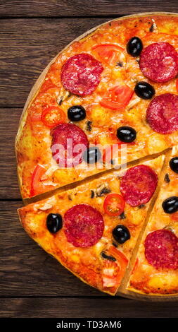 Pizza mince au salami, tomates cerises et olives noires Banque D'Images