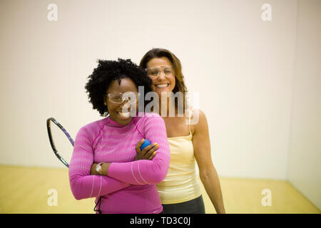 Portrait de deux femmes souriant debout sur un court de racquetball. Banque D'Images