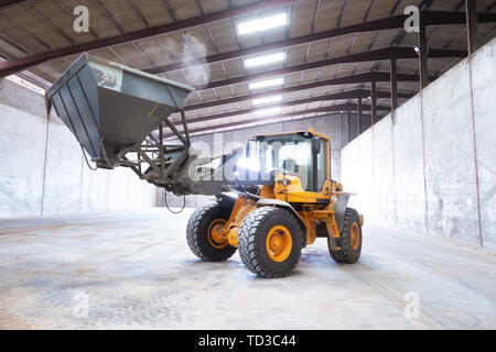 Pelle chargeuse sur roues. Machine de construction dans le hangar . Banque D'Images