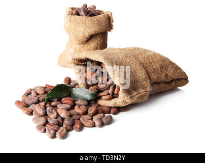 Les fèves de cacao dans des sacs avec des feuilles isolées sur fond blanc Banque D'Images