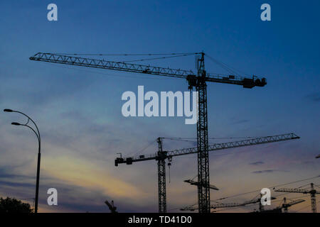 Groupe de grues de construction les bâtiments avec le Ciel de coucher du soleil sur l'arrière-plan Banque D'Images