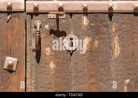 Serrure dans une vieille porte en bois orné de meubles anciens ; poignée de porte et patiné rouillé Banque D'Images